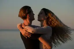 Para zapatrzona w siebie podczas zachodu słońca. Ona czuje się bezpiecznie w ramionach wrażliwego faceta.