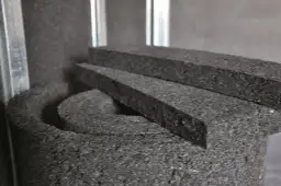 Czarne, porowate materiały izolacyjne, idealne do tego, jak wyciszyć okna, leżą obok metalowych profili.