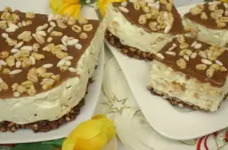 Kawałki ciasta z kremem, polewą czekoladową i ekspandowanymi płatkami.