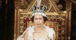 Królowa Elżbieta II w koronie i szacie, siedząca na tronie. Zastanawiamy się, ile żyła królowa Elżbieta, która panowała przez dekady.