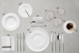 Nakrycie stołu: talerze, sztućce, szklanki, filiżanka kawy i serwetka.