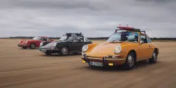 Trzy klasyczne Porsche 911 na plaży, żółte z deskami surfingowymi na dachu. Niesamowita fotografia samochodowa.