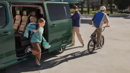 Dzieci wysiadają z zielonego vana, gotowe na skatepark. Czy opiekun osoby niepełnosprawnej płaci za bilet, by móc im towarzyszyć?