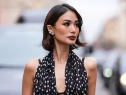 Elegancka fryzura na wesele włosy do ramion, z błyszczącymi dodatkami przy uchu i sukienka w grochy.