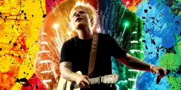 Ed Sheeran gra na gitarze na tle kolorowych eksplozji. Wyobraź sobie, kiedy Ed Sheeran zagra koncert w Polsce!