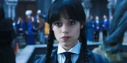 Wednesday Addams w okularach i krawacie, z niecierpliwością czekająca na drugi sezon.