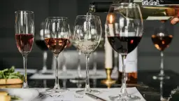 Degustacja win: ile kalorii ma kieliszek białego wina, a ile czerwonego i różowego? Kieliszki z winem białym, różowym i czerwonym na stole.