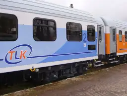 Wagon TLK z niebieskim pasem i logo. Czy w pociągach TLK są gniazdka? Warto sprawdzić, bo podróż z naładowanym telefonem jest przyjemniejsza.