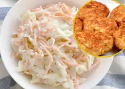 Surówka z białej kapusty i marchewki obok kotletów mielonych.