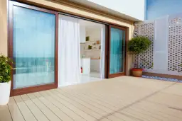 Jasne, oto opis:

Tarasy z drewnianą podłogą i dużymi, przesuwnymi oknami otwieranymi do góry, prowadzącymi do nowoczesnej kuchni.