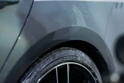 Krople wody na plastikowej części nadkola samochodu. Pytanie: czym odtłuścić plastik przed malowaniem?