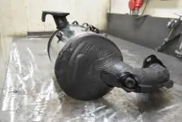 Filtr DPF z widocznymi uszkodzeniami i taśmą izolacyjną na metalowym stole.