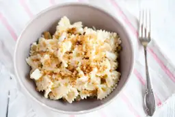 Pyszny makaron z kalafiorem w sosie śmietanowym, posypany chrupiącą panierką. Idealny na szybki obiad.
