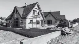 Budowa domów w toku. Scena pokazuje postęp prac, jak przenieść pozwolenie na budowę, gdy domy są w stanie surowym, z rusztowaniami i koparką.