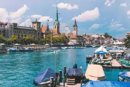 Widok na Zurych, największe miasto Szwajcarii, z rzeką Limmat, łodziami i zabytkową architekturą.