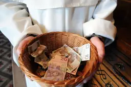Kosz z pieniędzmi, pytanie ile bierze kościelny za pogrzeb. Widać banknoty 10 i 20 zł.