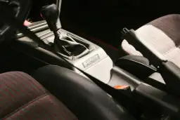 Widok wnętrza samochodu z dźwignią zmiany biegów i hamulcem ręcznym. Widoczna plakietka "KARMANN".