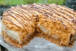 Pyszny deser Kunafa przepis. Chrupiąca, złocista skórka z cienkich nitek ciasta, przełożona kremowym nadzieniem i polana czekoladą.