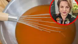 Mieszadło w misce z pomarańczową galaretką i kobieta w tle.