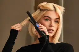 Blondynka używa prostownicy Remington, by nadać objętość włosom u nasady.