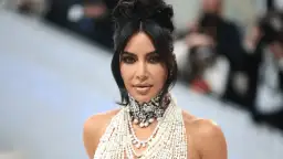 Kim Kardashian na Met Gali w olśniewającej kreacji z pereł i kryształów, z charakterystyczną fryzurą i makijażem.