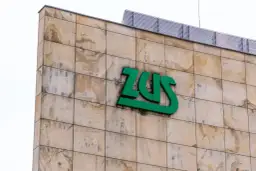 Zielone logo ZUS na beżowej, kamiennej elewacji. Czy chorobowe wlicza się do lat pracy? Zapytaj w ZUS.