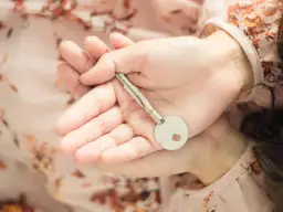 Dłonie trzymające klucz, symbolizujący, co to lojalność – otwarcie serca i zaufanie.