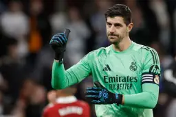Thibaut Courtois, jeden z kapitanów Realu Madryt, w zielonej koszulce bramkarskiej, pokazuje kciuk w górę.