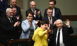 Kiedy rządził PiS, Beata Szydło w żółtej marynarce i Jarosław Kaczyński w garniturze pozdrawiają tłum.