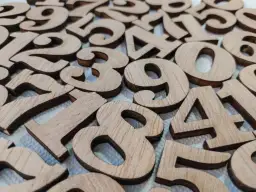 Drewniane cyfry naturalne ułożone na białym tle.