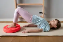 Dziecko ćwiczy na poduszce sensorycznej dla dzieci z ADHD, poprawiając równowagę i koordynację.