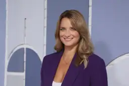 Dagmara Kaczmarek Szałkow w fioletowej marynarce, znana z Faktów TVN, uśmiecha się do kamery.
