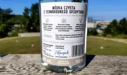 Etykieta butelki wódki czystej opisuje różnicę między wódką czystą zbożową a ziemniaczaną w smaku i aromacie, podkreślając ziemniaczaną jako aksamitną z nutą ziemniaka.