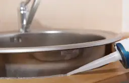 Aplikacja silikonu wokół zlewu kuchennego.