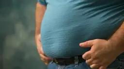 Mężczyzna z widocznym brzuchem, symbolizującym problemy zdrowotne, takie jak zespół metaboliczny. Dieta jest kluczowa w walce z tym schorzeniem.