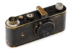 Antyczny aparat Leica, prawdopodobnie najdroższy aparat fotograficzny na świecie, z widocznym napisem "O.B." i złotymi detalami.