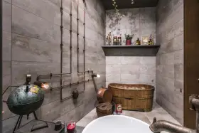 Ambiance unique dans cette salle de bain industrielle avec baignoire en bois, tuyauterie apparente et lampes vintage.