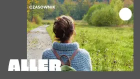 Osoby po francusku, spacerujące jesienną alejką wśród kolorowych drzew.