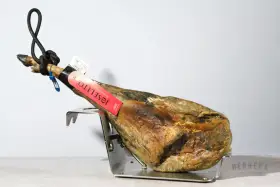 Jamón Joselito en soporte metálico, con etiqueta roja y negra.