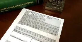 Zielona księga z tytułem "Kodeks postępowania cywilnego" i dokument z polami do wypełnienia.