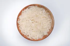 Miseczka z ryżem parboiled na białym tle.