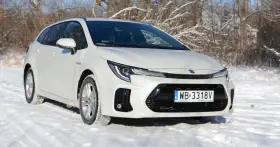 Biały Suzuki Swace Hybrid na śniegu, gotowy na zimowe wyzwania.