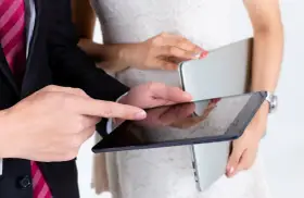 Para młoda planuje zmianę dowodu po ślubie, przeglądając dokumenty na tablecie.