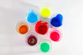 Kolorowe farby w kubeczkach, idealne jako jaka farba do plastiku na zewnątrz. Odcienie czerwieni, niebieskiego, żółtego, zielonego, pomarańczowego i różowego.