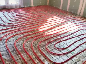 Instalacja ogrzewania podłogowego z rurkami w kolorze czerwonym, gotowa pod wylewki anhydrytowe. Sprawdź wylewki anhydrytowe cena za 1m2.