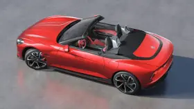 Czerwony MG Roadster z otwartym dachem, sportowe wnętrze, nowoczesne felgi i aerodynamiczne linie.