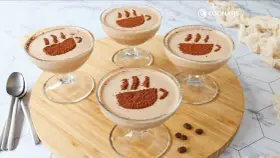 Cuatro copas de delicioso mousse de café, decoradas con cacao en polvo simulando una taza humeante.