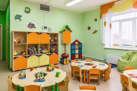 Kolorowy żłobek z zabawkami i stolikami. Czy żłobek jest płatny? To zależy od placówki, ale tutaj dzieci bawią się wesoło.