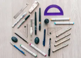 Herramientas de dibujo: reglas, escuadras, transportador, marcadores, bolígrafos y un sacapuntas. ¡Todo listo para crear!