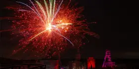 Feuerwerk über Herten: Ein Spektakel, das an eine Extraschicht der Freude erinnert. Rote und gelbe Funken sprühen, während ein Förderturm in Pink leuchtet.